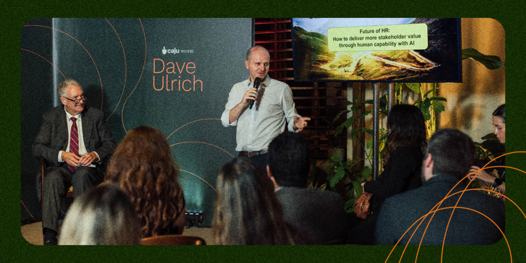 Eduardo del Giglio, CEO da Caju, fala com os convidados do evento ao lado de Dave Ulrich